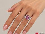 a woman ' s hand with pink manicured nails and a pink ring