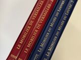 trois livres sont empilés sur une table