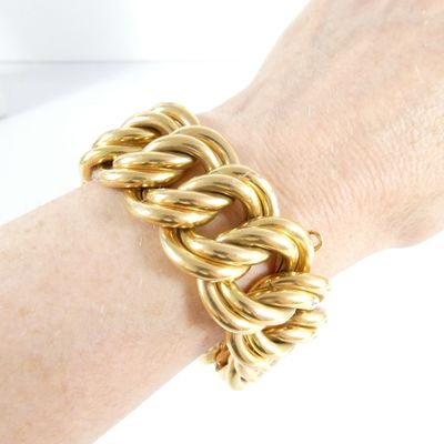 a close up of a person ' s hand wearing a gold chain bracelet