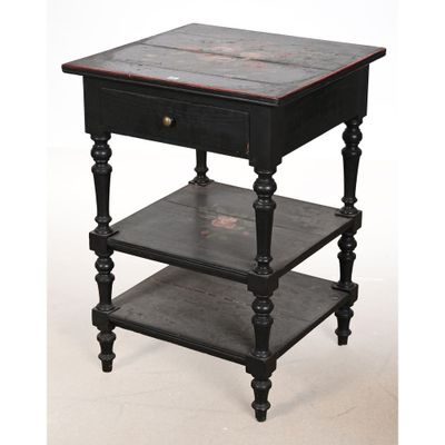 une vieille table noire comportant trois étagères et un tiroir sur le dessus