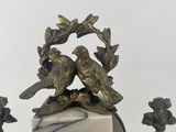 a clock that has birds on top of it