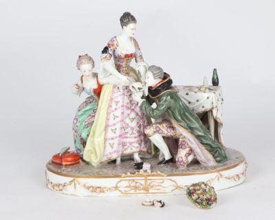 a figurine of a woman and two children sitting on a bench