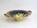 a blue and yellow bowl with handles on a white surface