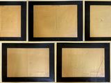 quatre cadres noirs ornés de dessins, posés sur une surface blanche