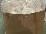 un sac marron contenant des balles blanches, posé par terre