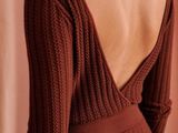the back of a woman wearing a brown sweater and skirt