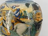 a vase with a picture of a man riding a horse on it