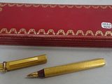 a red box with a gold pen and a red box with a gold pen