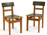 une paire de chaises en bois avec des assises en cuir noir, sur fond blanc