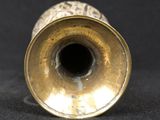a gold vase sitting on a black surface
