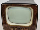 an old fashioned television sitting on a white surface