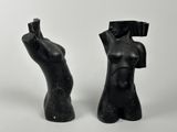 pair of black sculptures of a female torso and a male torso on a white background