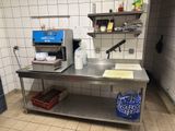 une cuisine avec une table en inox et un appareil bleu