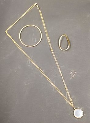 un collier, une bague et une boucle d'oreille posés sur une table