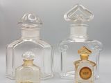 two clear glass bottles with a gold emblem on the top of them