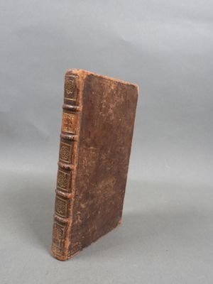 an old book sitting on top of a white surface