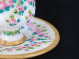 a small cup and saucer sitting on a small plate