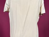 a white shirt on a mannequin stand against a red background