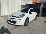 la petite voiture blanche est garée devant un bâtiment