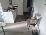 a room with a desk, chair, and other items in it