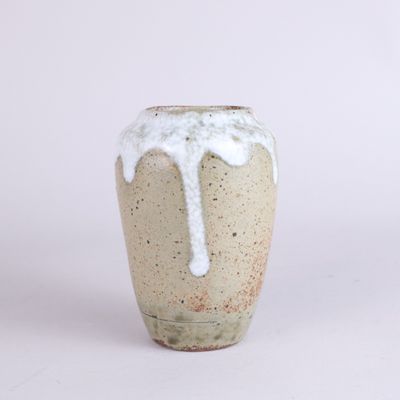 a white and brown vase with white glazes on it