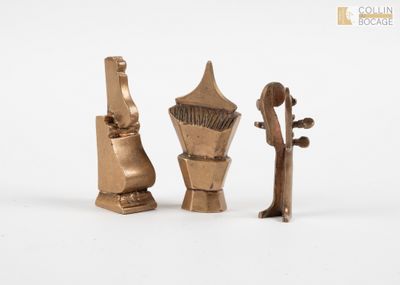 trois morceaux de métal sont posés sur une surface blanche