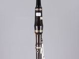 a close up of a clarinet on a clear surface with a gray background
