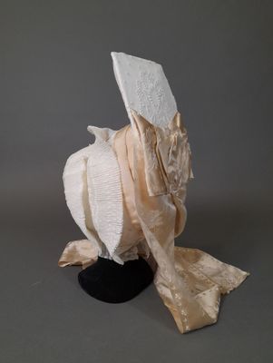 une sculpture représentant un oiseau coiffé d'un chapeau