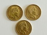 three gold sovereigns, one of which has a head of a man and two of which is a woman