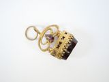 a close up of a gold plated pendant with a purple stone
