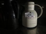 une cruche blanche avec un autocollant, posée sur un comptoir
