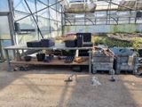 de nombreux bacs contenant des plantes, posés sur une table dans une serre