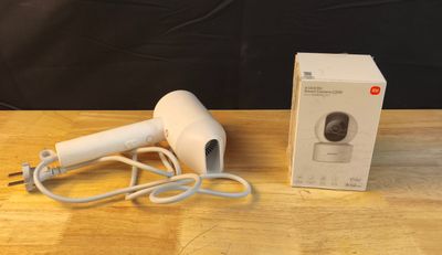 un sèche-cheveux blanc posé sur une table à côté d'une boîte