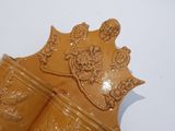 a brown vase with a crown on it sitting on a table