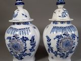 two blue and white vases with lids on a gray surface