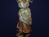 a bronze statue of a woman with a bird on her head