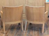 two wooden chairs that are sitting on a wooden floor