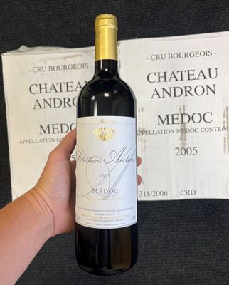 une personne tenant une bouteille de vin à la main