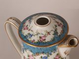 a blue and white tea pot with flowers on it