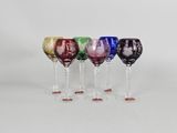 six different colored wine glasses are lined up in a row