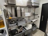 une cuisine où les étagères sont remplies de vaisselle et de casseroles