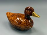 un canard en céramique posé sur une table