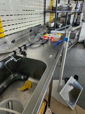 un évier de cuisine avec un plan de travail encombré