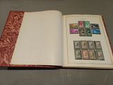 an open book with stamps on it sitting on a table