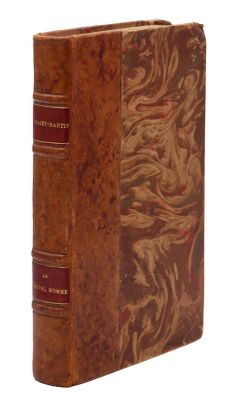 an old book with a brown cover sitting on top of a white surface