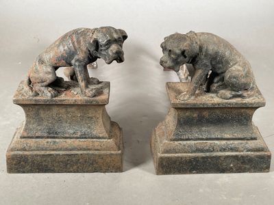 deux statues représentant un chien et un chat, posées sur un socle