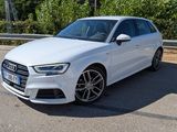 L'Audi blanche est garée sur le bord de la route.
