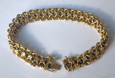 gros plan d'un bracelet en or sur une surface blanche