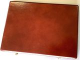 brown leather briefcase on a white surface with a white background