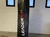 a black punching bag hanging from the ceiling in a garage